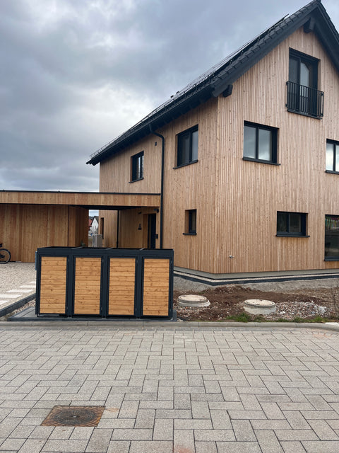 Wood-clad BIO Stefan bin box in front of a modern house.