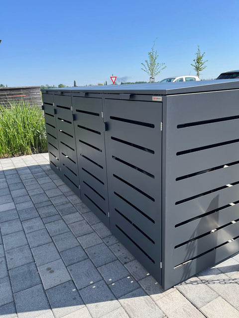 Zwarte box voor vuilnisbakken van BIO Stefan op een terras met bestrating.