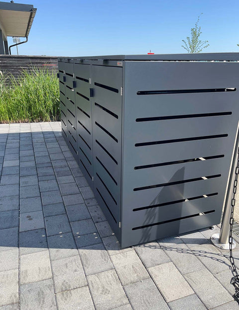 Box voor vuilnisbakken van BIO Stefan van grijs metaal op een betegelde ondergrond.