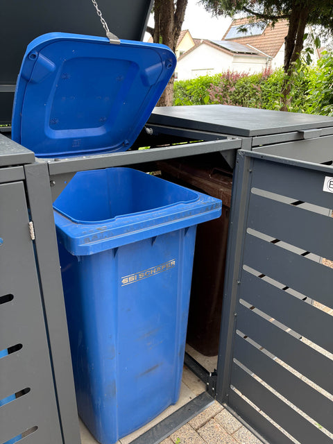 Bio Stefan box voor vuilnisbakken met geopend deksel en blauwe vuilnisbak.