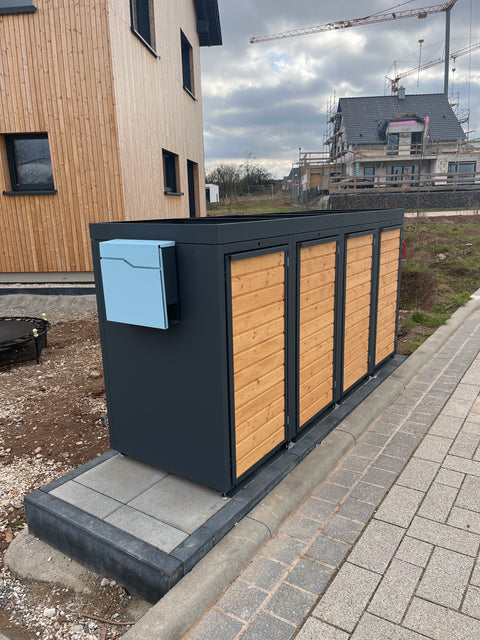 Garbage bin box by BIO Stefan with wooden cladding in front of a modern house.