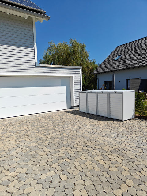 Modern garbage bin box by BIO Stefan in front of a white building on a paved courtyard.