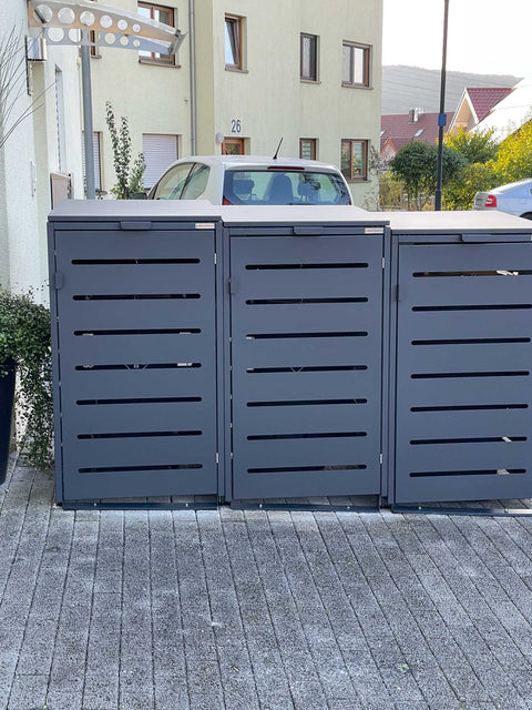 BIO Stefan Alubert Mülltonnenbox 3er 240l in Anthrazit auf abschüssiger gepflasterter Einfahrt im Wohngebiet
