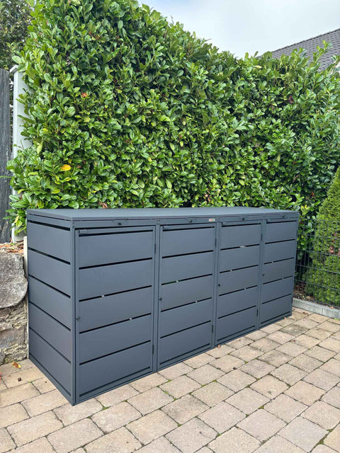 BIO Stefan Dagobert Mülltonnenbox 4er 240l in Anthrazit vor grüner Hecke auf gepflasterter Terrasse