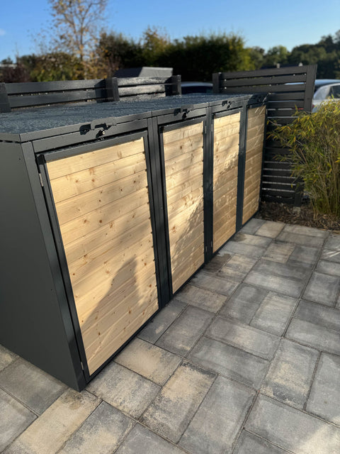 Bio Stefan Holzmichl Mülltonnenbox 4er Kombination 120l 240l anthrazit mit Holzfront auf gepflasterter Terrasse