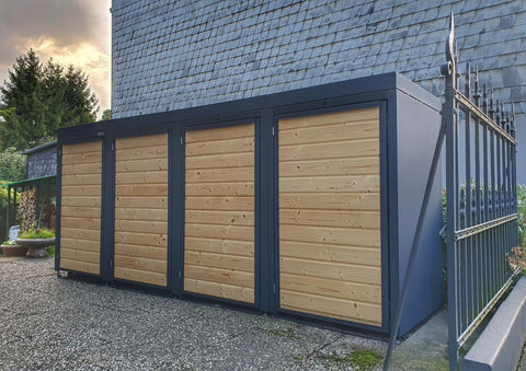 BIO Stefan Holzmichl Mülltonnenbox 4er Kombination 120l/240l in Anthrazit mit Holzfront neben Hausfassade