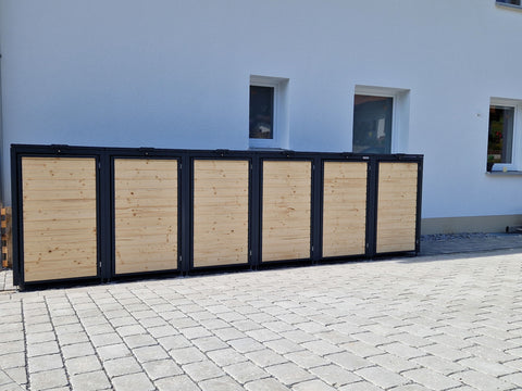 BIO Stefan Holzmichl Mülltonnenbox 6er 240l in Anthrazit RAL 7016 mit geschlossenen Klappdeckeln vor hellem Neubau