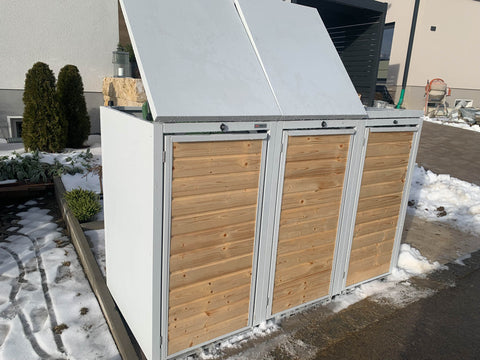 BIO Stefan Holzmichl Mülltonnenbox 3er 120l in Reinweiß RAL 9010 mit zwei nach hinten geöffneten Klappdeckeln neben der Einfahrt