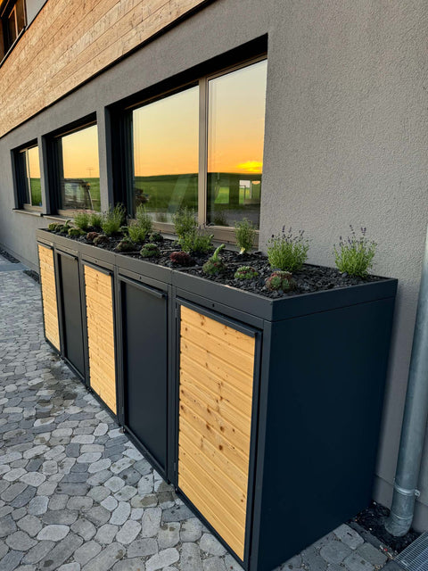 BIO Stefan Holzmichl Mülltonnenbox 5er 240l in Anthrazit mit Holzfront und Pflanzdach entlang der Hauswand auf Natursteinpflaster