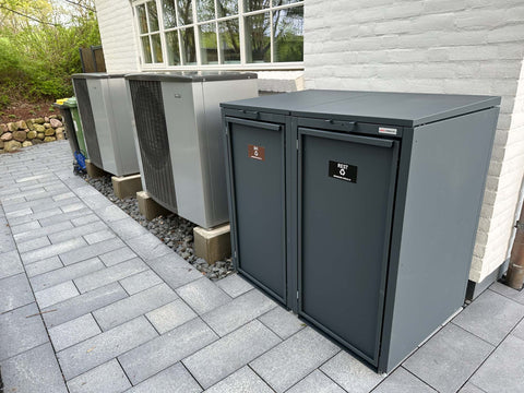 BIO Stefan Stahlfred Mülltonnenbox 2er 120l in Anthrazit auf gepflasterter Terrasse neben der Wärmepumpe an der Hauswand