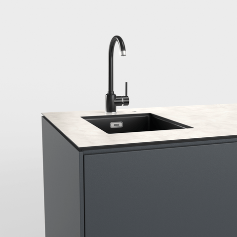 Moderne Spüle mit schwarzem Wasserhahn in einer Küchenzeile.