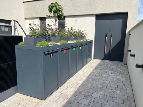 Cutie pentru pubele BIO Stefan extensibilă 4 boxuri în antracit cu acoperiș pentru plante în fața unui perete modern al casei